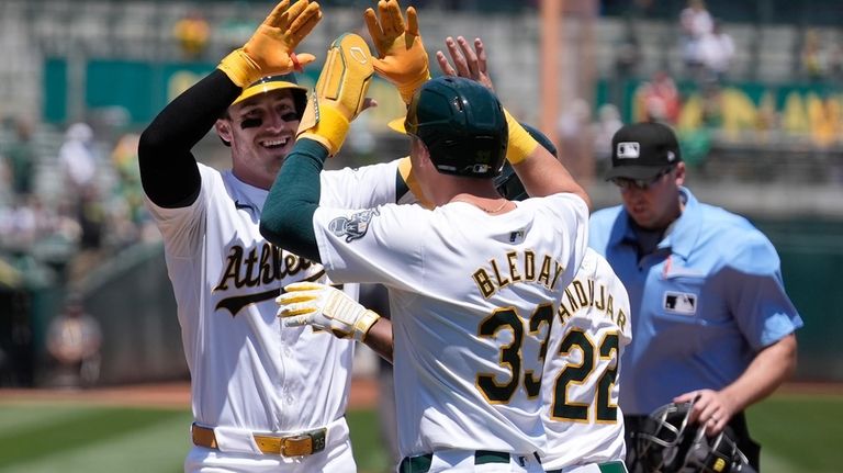 Oakland Athletics' Brent Rooker, left, celebrates after hitting a three-run...