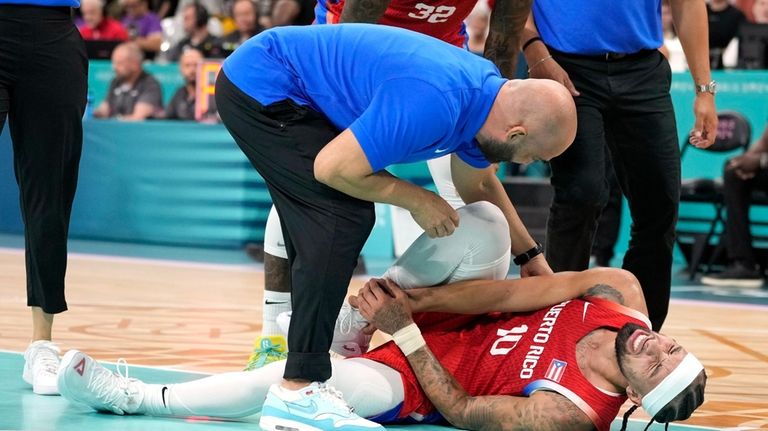 Jose Alvarado, of Puerto Rico, is checked on after being...