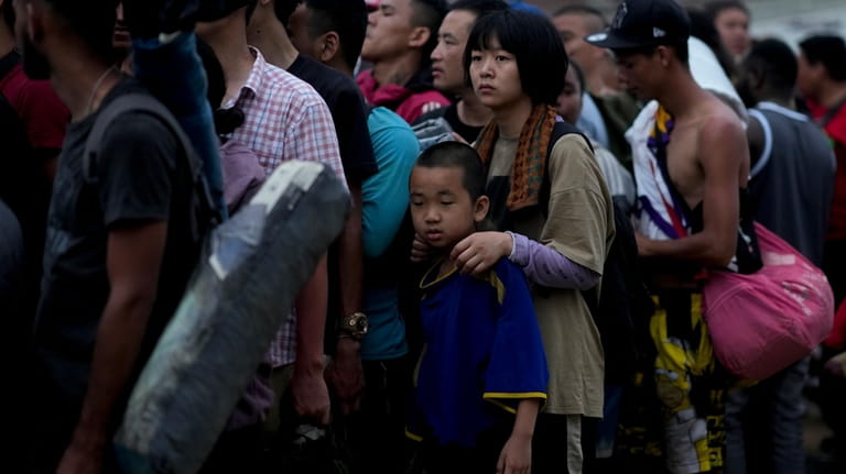 Chinese migrants line up to take a boat to Lajas...