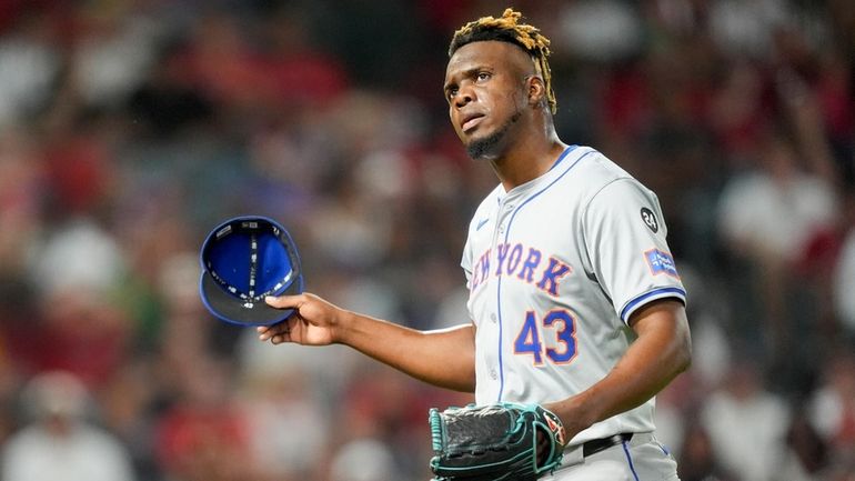 Mets relief pitcher Huascar Brazoban walks off the field after...