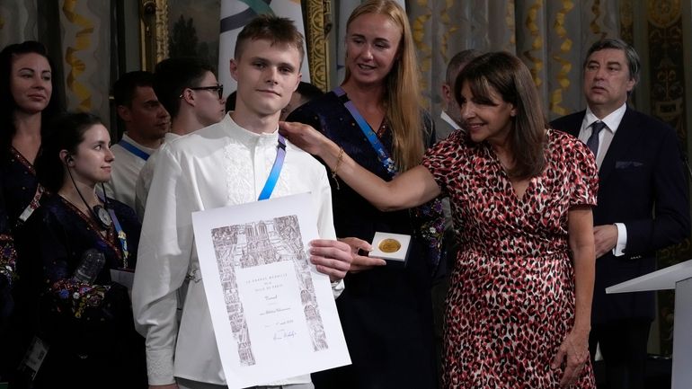 Paris mayor Anne Hidalgo, right, awards Ukrainian athletes Oleskii Sereda...