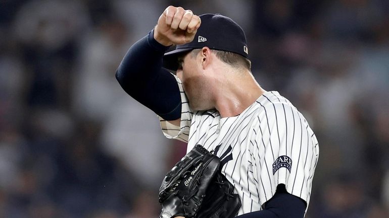 Clay Holmes of the Yankees reacts after surrendering a ninth-inning two-run...