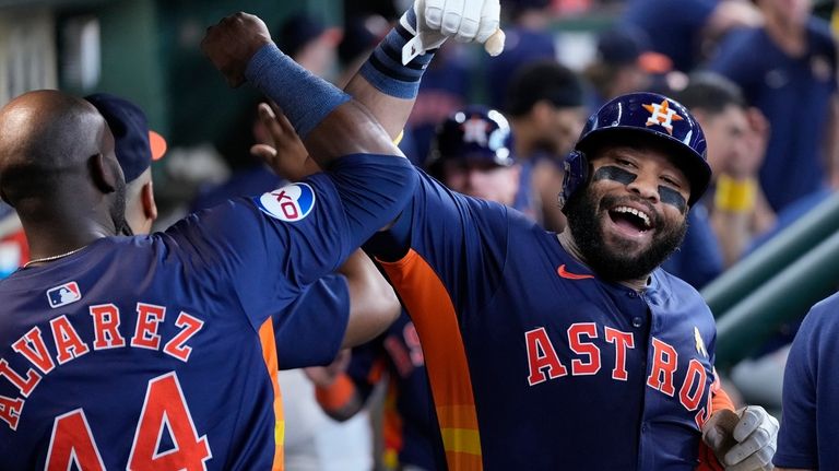 Houston Astros' Jon Singleton, right, is congratulated by Yordan Alvarez...