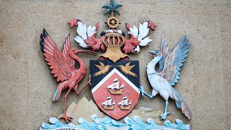 The country's coat of arms hangs at the entrance of...