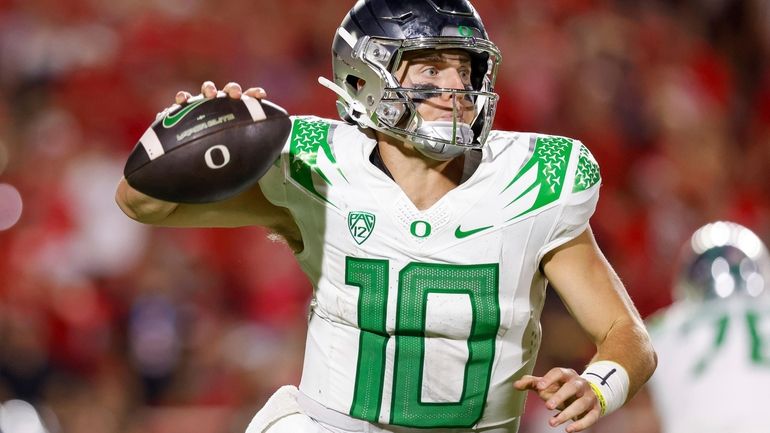 Oregon quarterback Bo Nix rolls out of the pocket against...