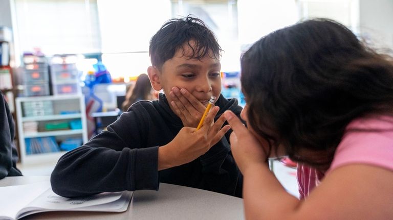 A fifth grade student explains a math answer to his...