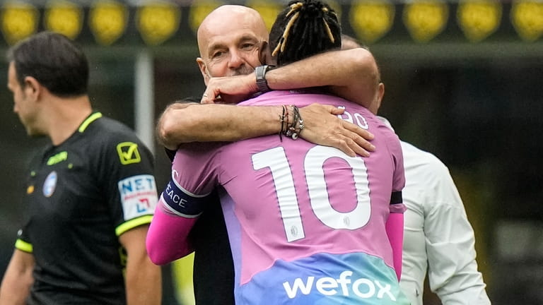 AC Milan's Rafael Leao celebrates with coach Stefano Pioli after...