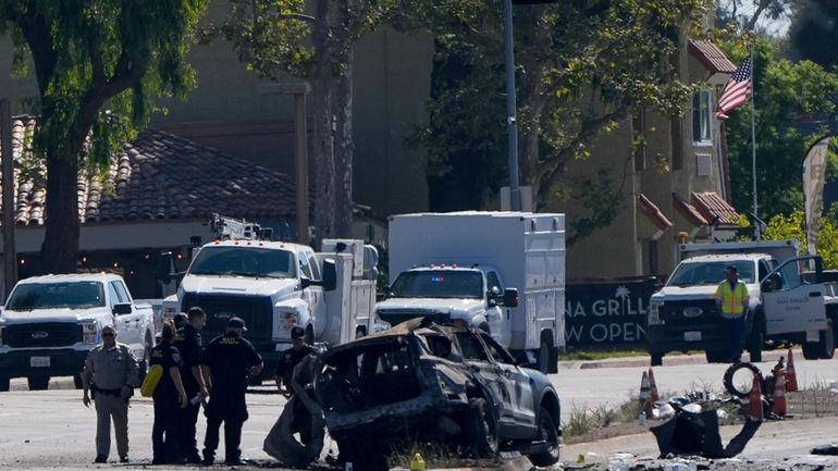 A charred police vehicle is seen in aftermath of an...