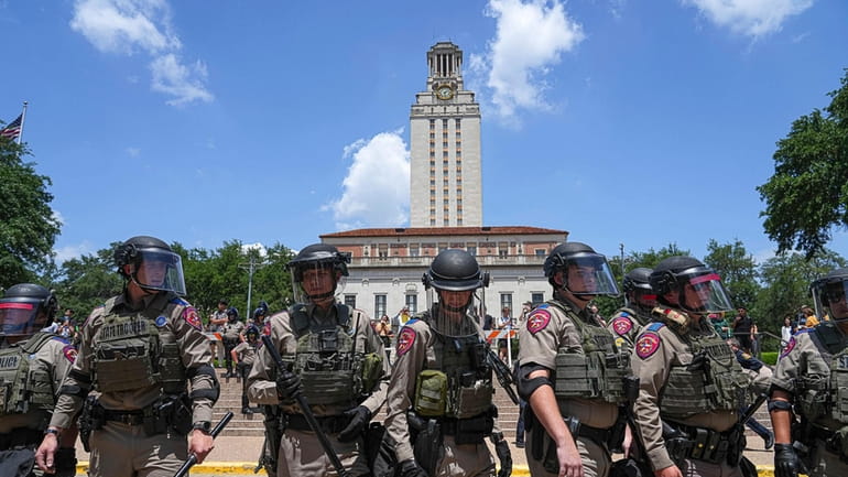 Texas state troopers line up below the University of Texas...