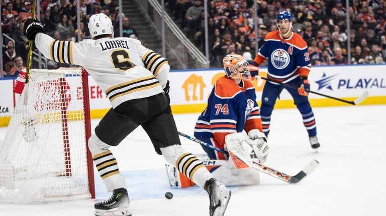 Boston Bruins' Mason Lohrei (6) reacts as the puck goes...