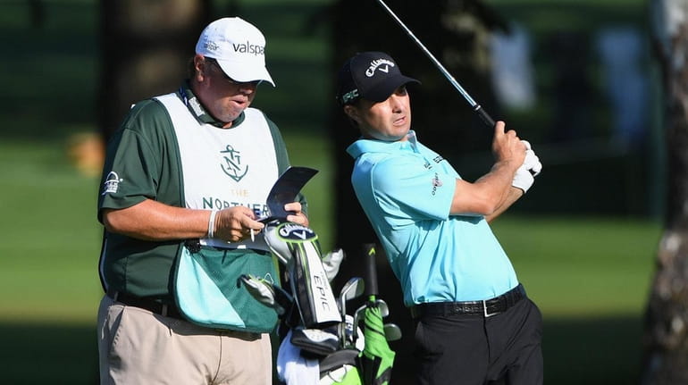 Caddie Duane Bock stands with golfer Kevin Kisner on the...