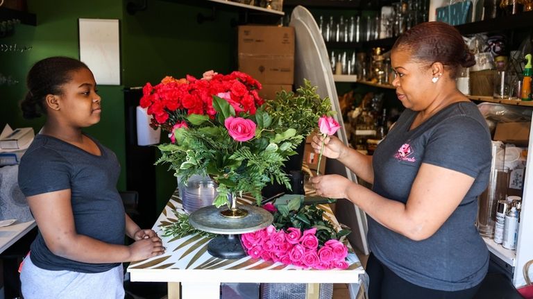 Marjorie Bien-Aime, of Baldwin, makes a floral arrangement alongside her...