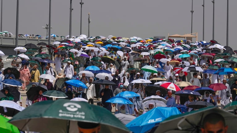 Muslim pilgrims use umbrellas to shield themselves from the sun...
