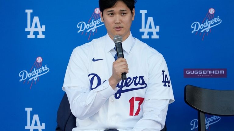 Los Angeles Dodgers' Shohei Ohtani answers questions during a baseball...