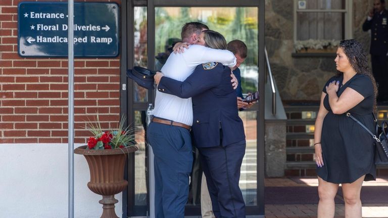 Mourners console each other as they attend the visitation for...