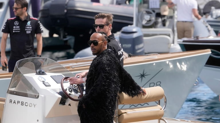 Mercedes driver Lewis Hamilton of Britain stands on a boat...
