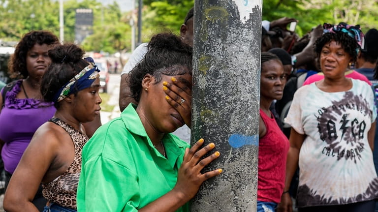 A woman cries after her relatives went missing following clashes...