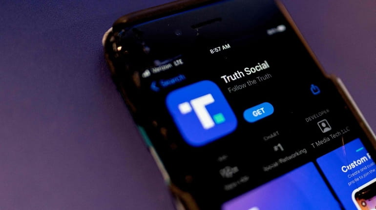 A phone screen displays the Truth Social app in Washington,...