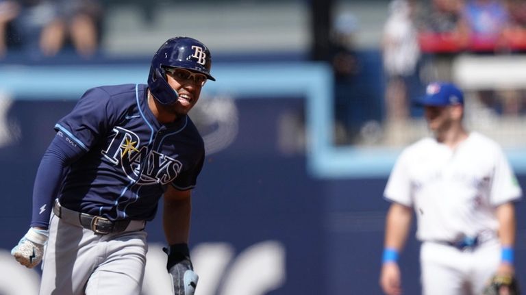 Tampa Bay Rays' Richie Palacios rounds third base to score...