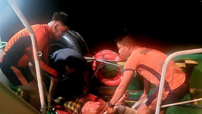 In this photo provided by the Philippine Coast Guard, rescuers...