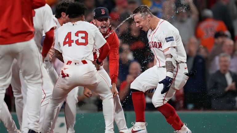 Boston Red Sox's Tyler O'Neill is greeted by teammates at...