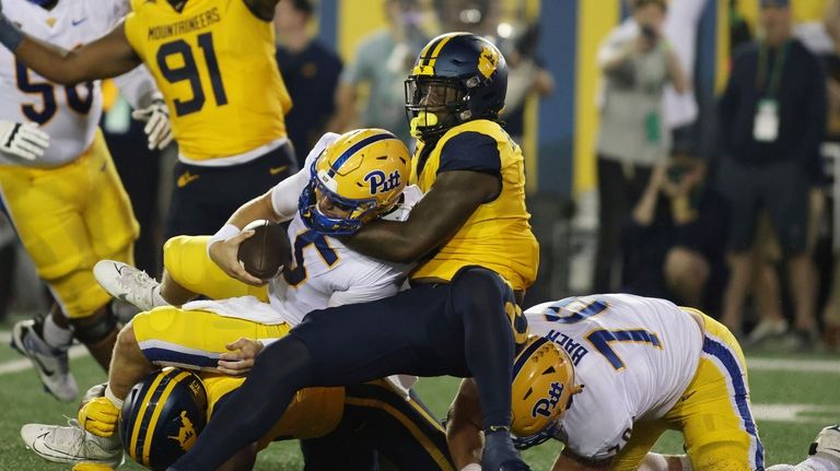 West Virginia's Turin Bradley (8) sacks Pittsburgh quarterback Phil Jurkovec...