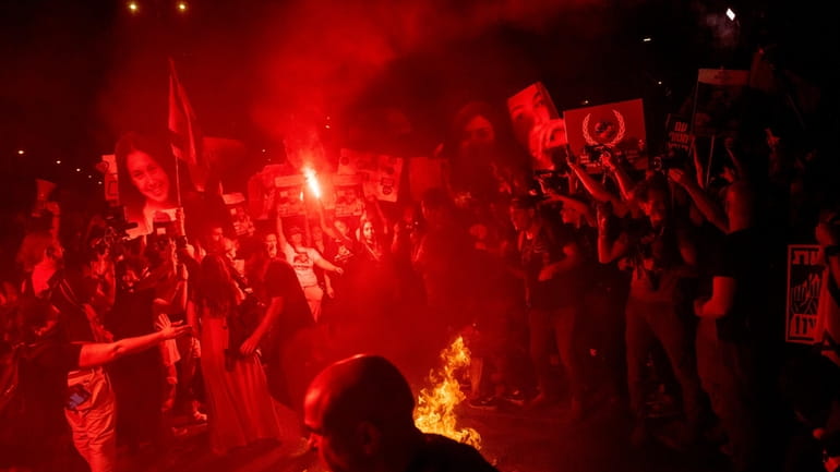 Demonstrators burn fire during a protest against Israeli Prime Minister...