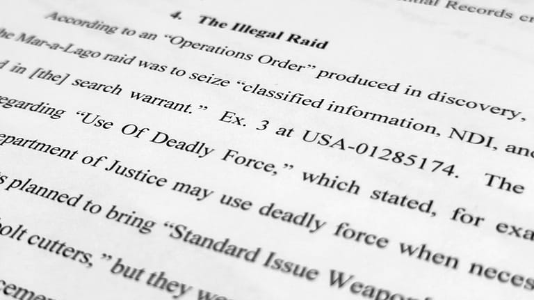 A page from a Trump defense motion filing is photographed...