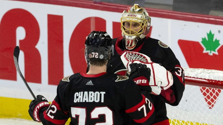 Ottawa Senators defenseman Thomas Chabot congratulates goaltender Anton Forsberg after...