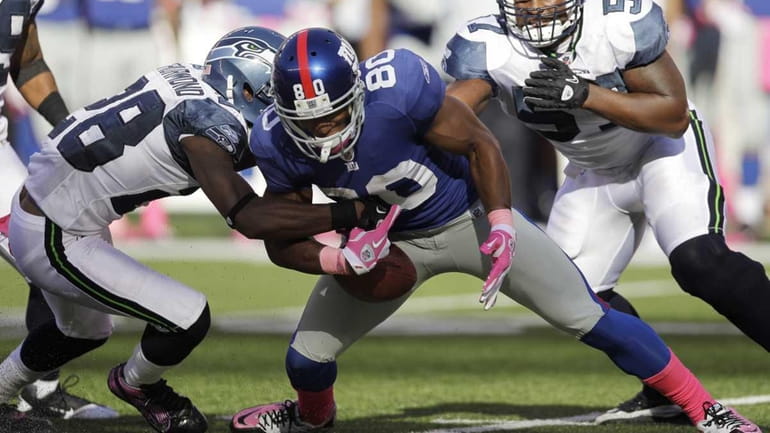 New York Giants wide receiver Victor Cruz fumbles the ball...