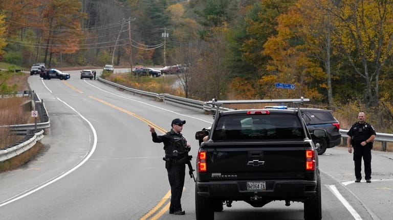 Police officers speak with a motorist at a roadblock, Thursday,...