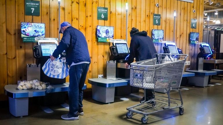 Customers use self-checkout kiosks at Stew Leonard's grocery store in...