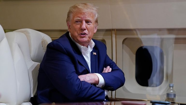 Former President Donald Trump speaks with reporters while in flight...