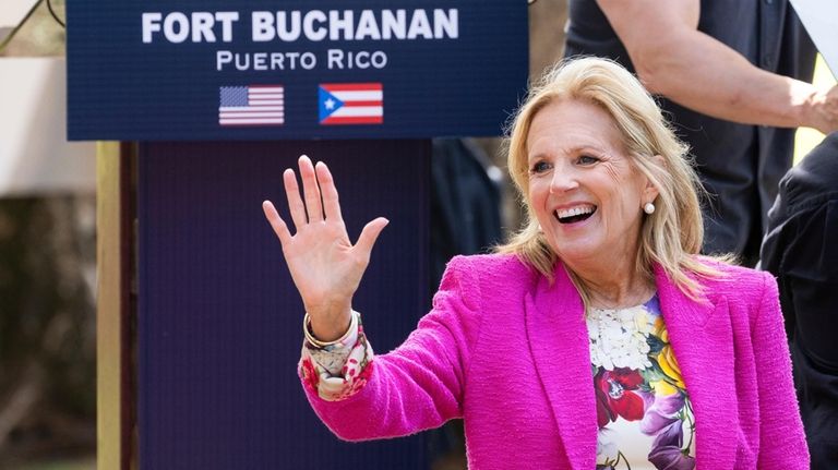 First Lady Jill Biden waves to attendees during an event...