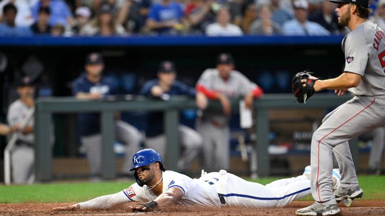 Kansas City Royals' MJ Melendez, bottom, scores on a passed...