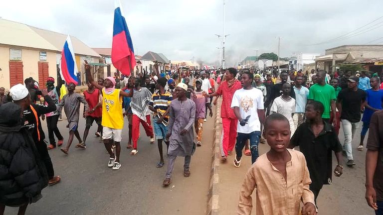 People wave Russian flags during a protest in Kaduna, Nigeria,...