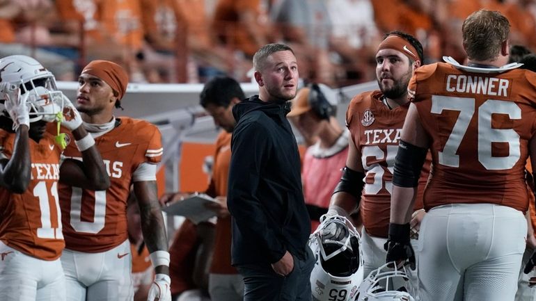 Texas quarterback Quinn Ewers, center, stands on the sidelines in...