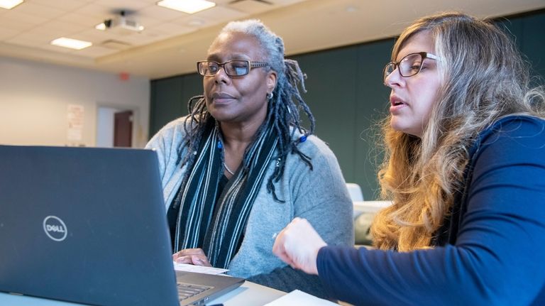 Taxpayer Miranda Barnes of Amityville, left, consults with VITA volunteer Amanda...