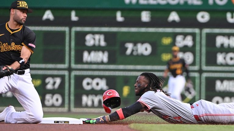 Cincinnati Reds' Elly De La Cruz, right, slides safely into...