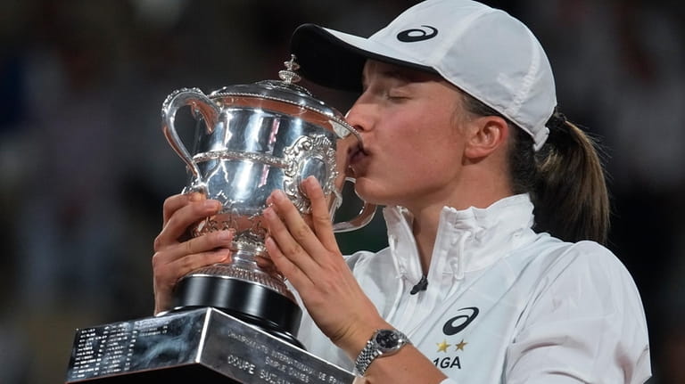 Poland's Iga Swiatek kisses the trophy after winning the final...