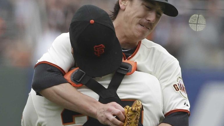 San Francisco Giants pitcher Tim Lincecum is embraced by catcher...