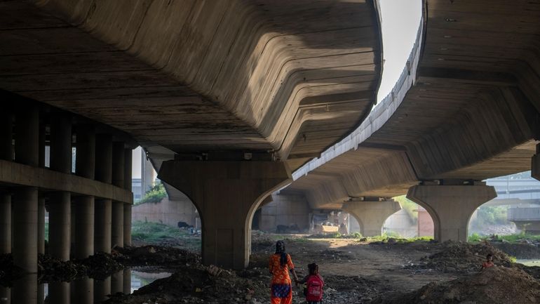 Meera Devi, left, accompanies her daughter Arima, 7, to her...