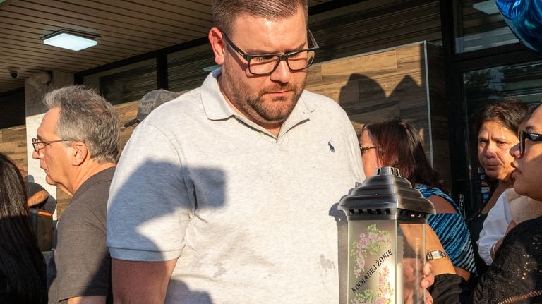 NYPD Det. Carl Rennhack carries a candle for his wife, NYPD...