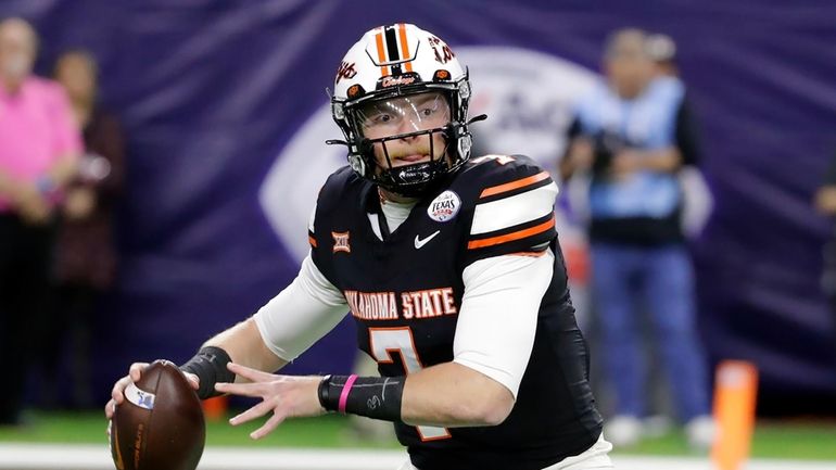 Oklahoma State quarterback Alan Bowman looks to pass the ball...