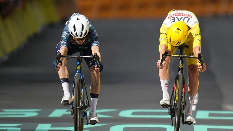 Denmark's Jonas Vingegaard, left, pushes his wheel over the finish...