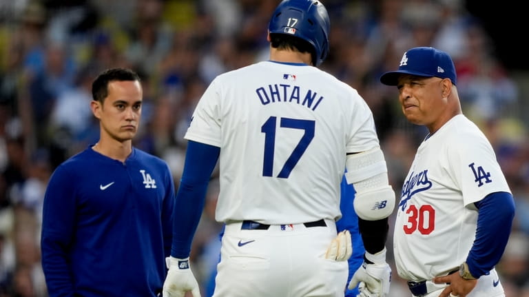 Los Angeles Dodgers designated hitter Shohei Ohtani, front center, speaks...