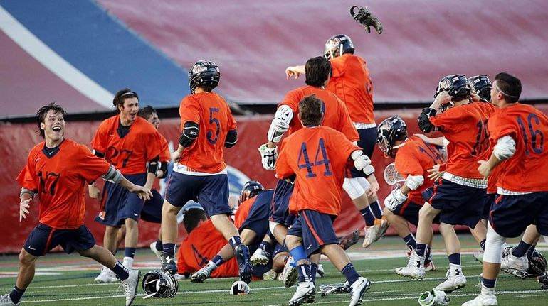 The Manhasset boys lacrosse team celebrates its last-minute victory over...