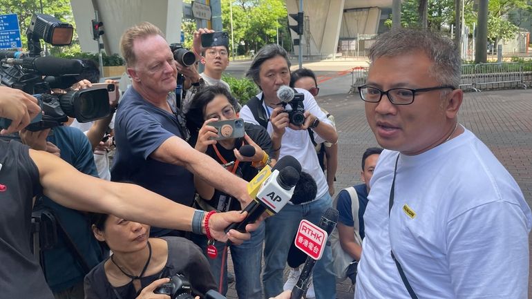 Hong Kong Journalists Association's Chairman Ronson Chan, right, speaks to...