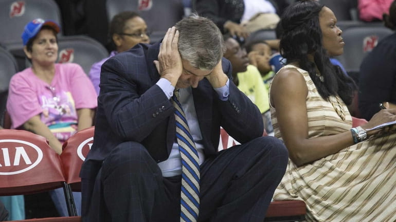 Liberty head coach Bill Laimbeer hangs his head as his...