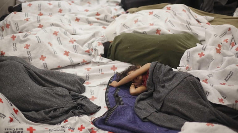A detainees sleep in a holding cell at a U.S....